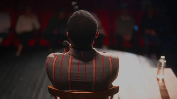 black-ethnic-stand-up-comedian-talking-on-stage.png